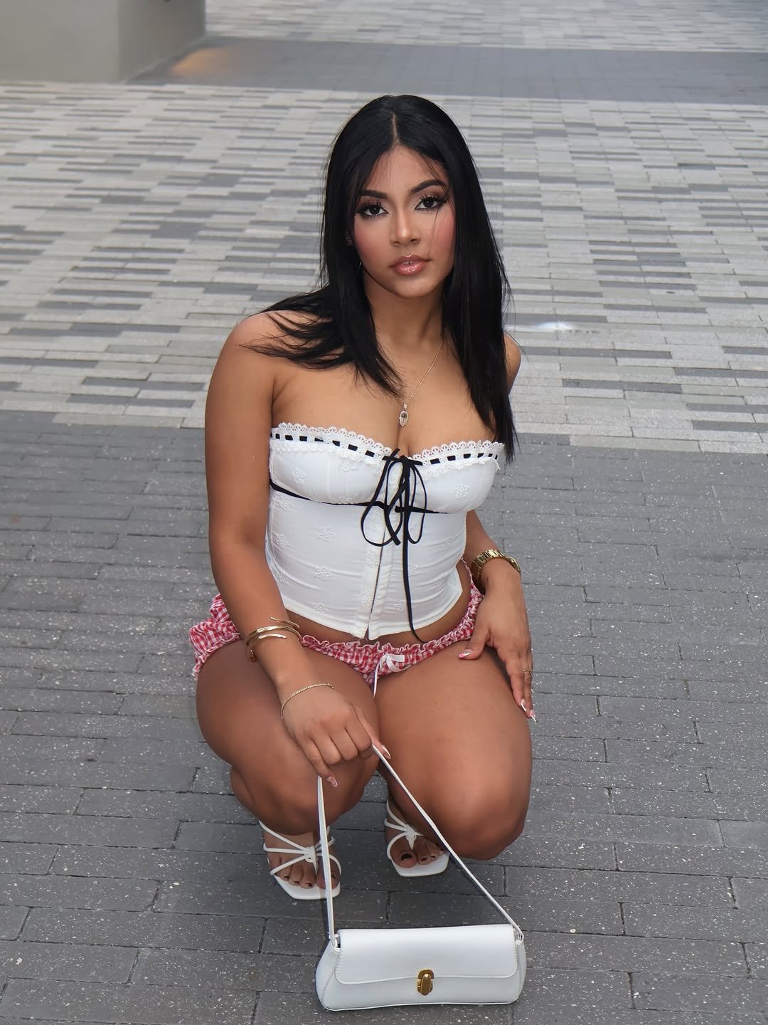 Daniela crouching with a white bag