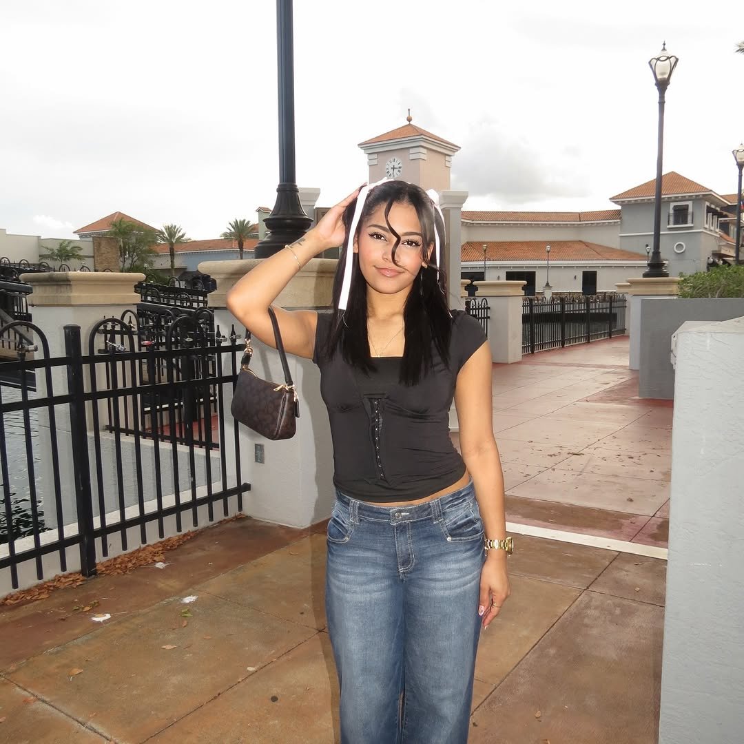 Daniela smiling with hand at forehead