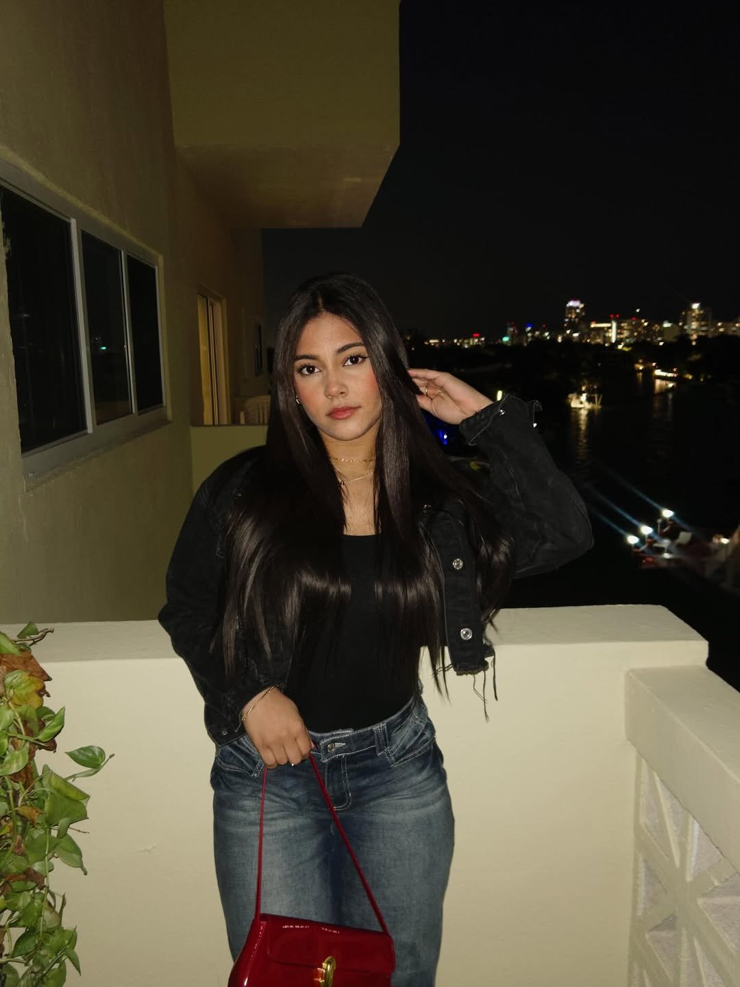 Daniela on a balcony over the Miami skyline at night