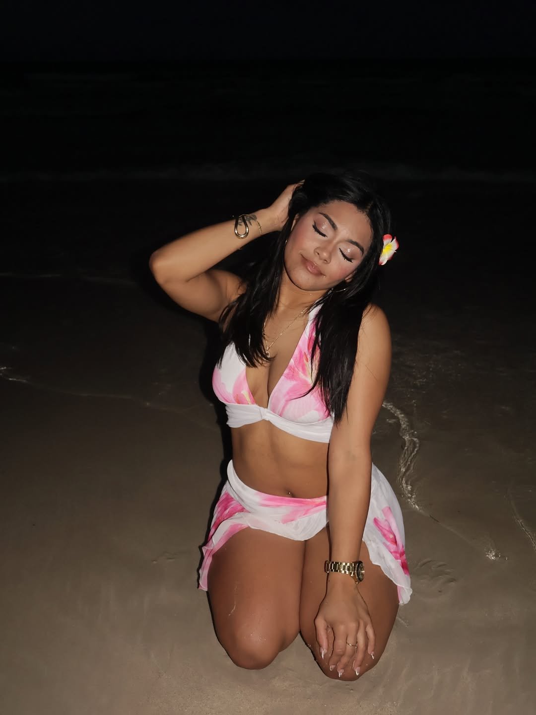 Daniela kneeling on the sand at night